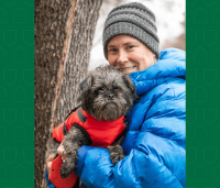 Woman holding her 14-week-old schnauzer-pug mix puppy.